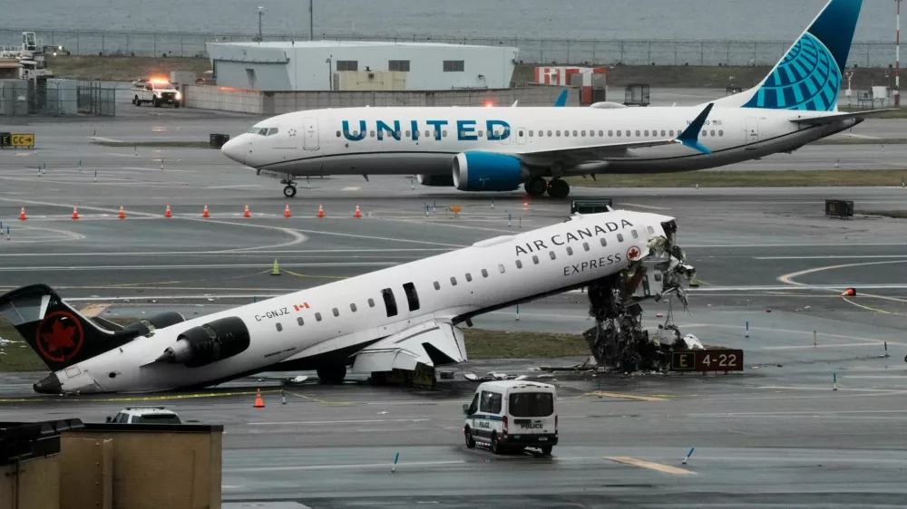 A United Airlines aircraft taxis next to the wreckage of an Air Canada Express jet that collided with a fire truck at New York's LaGuardia Airport in Queens, New York, U.S., March 23, 2026. REUTERS/Eduardo Munoz
