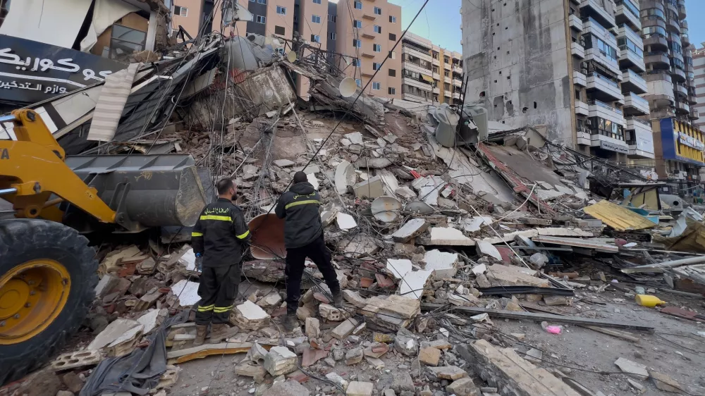 Civil defense workers check a destroyed building that was hit by an Israeli airstrike in Dahiyeh, Beirut's southern suburbs, Lebanon, Tuesday, March 24, 2026. (AP Photo/Hussein Malla)