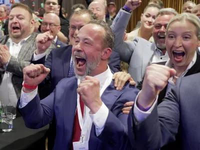 The AfD's top canditate Jan Bollinger, front, and Alice Weidel, right, chairwoman of the Alternative for Germany party (AfD) parliamentary group, celebrate in Mainz, Germany, Sunday, March 22, 2026, after the forecast of the results of the German state election in Rhineland-Palatinate. (Andreas Arnold/dpa via AP)