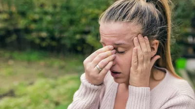 Woman with headache. Seasonal allergies and health problems. Sinus ache causing very paintful headache. Unhealthy woman in pain. Sharp strong sore. Flu cold or allergy symptom. Sinus pain, sinusitis.