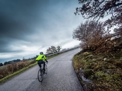 cyclist trains along a mountain road during a stormcyclist are training on a rainy day