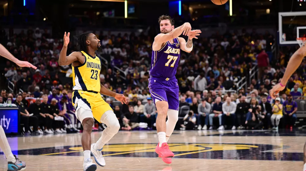 Mar 25, 2026; Indianapolis, Indiana, USA; Los Angeles Lakers guard Luka Doncic (77) passes the ball away from Indiana Pacers guard Aaron Nesmith (23) during the second half at Gainbridge Fieldhouse. Mandatory Credit: Marc Lebryk-Imagn Images