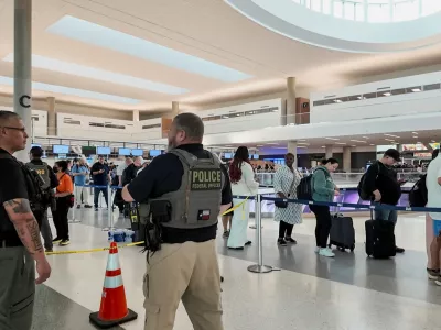 Two Immigration and Customs Enforcement (ICE) agents observe passengers waiting in long TSA lines amid a funding standoff that has forced 50,000 airport security officers to go without pay, causing delays at airports, at the George Bush Intercontinental Airport in Houston, Texas, U.S., March 25, 2026, in this screengrab from video. REUTERS/Evan Garcia