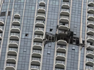 Workers inspect damage caused by a drone strike overnight at the Address Creek Harbour hotel in Dubai, United Arab Emirates, March 12, 2026. (AP Photo/Fatima Shbair)