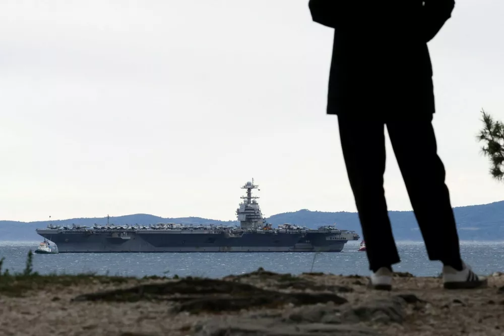 A person looks on as U.S. aircraft carrier "Gerald R. Ford" holds position in front of Split, in the Adriatic Sea, March 28, 2026. REUTERS/Antonio Bronic