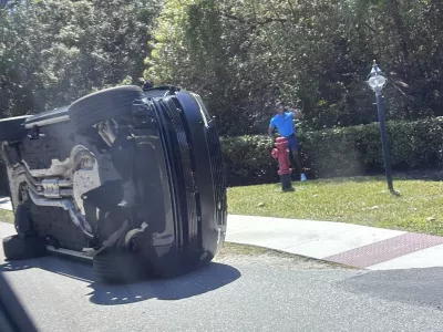 Golfer Tiger Woods stands by his overturned vehicle in Jupiter Island, Fla., on Friday, March 27, 2026. (AP Photo/Jason Oteri)