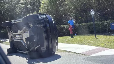 Golfer Tiger Woods stands by his overturned vehicle in Jupiter Island, Fla., on Friday, March 27, 2026. (AP Photo/Jason Oteri)