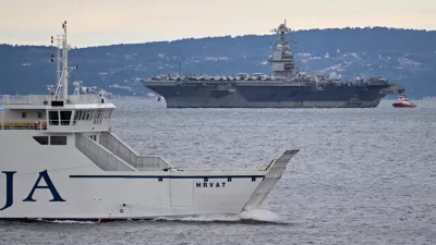 A Croatian ferryboat sails by as USS Gerald R. Ford arrives to the port of Split, Croatia, Saturday, March 28, 2026. (AP Photo/Tom Dubravec)