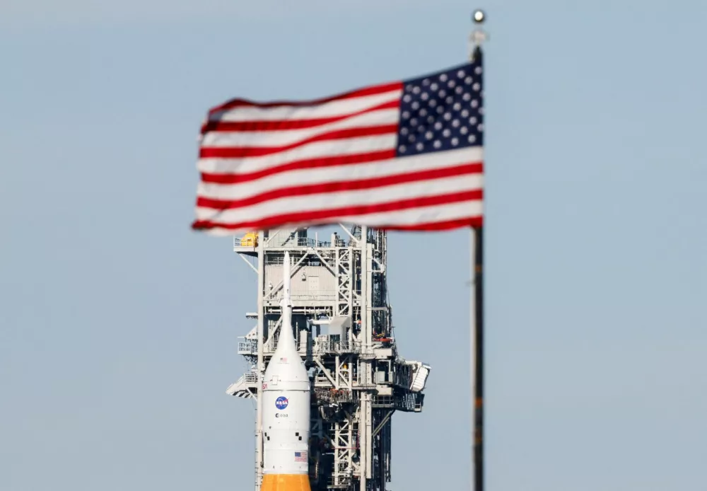 NASA's next-generation moon rocket, the Space Launch System (SLS) rocket with the Orion crew capsule, rolls from its launch pad back to the Vehicle Assembly Building for repairs ahead of the Artemis II mission launch at the Kennedy Space Center in Cape Canaveral, Florida, U.S., February 25, 2026. The capsule is behind the press site flag. Launch is scheduled no earlier than April 1, 2026. REUTERS/Joe Skipper