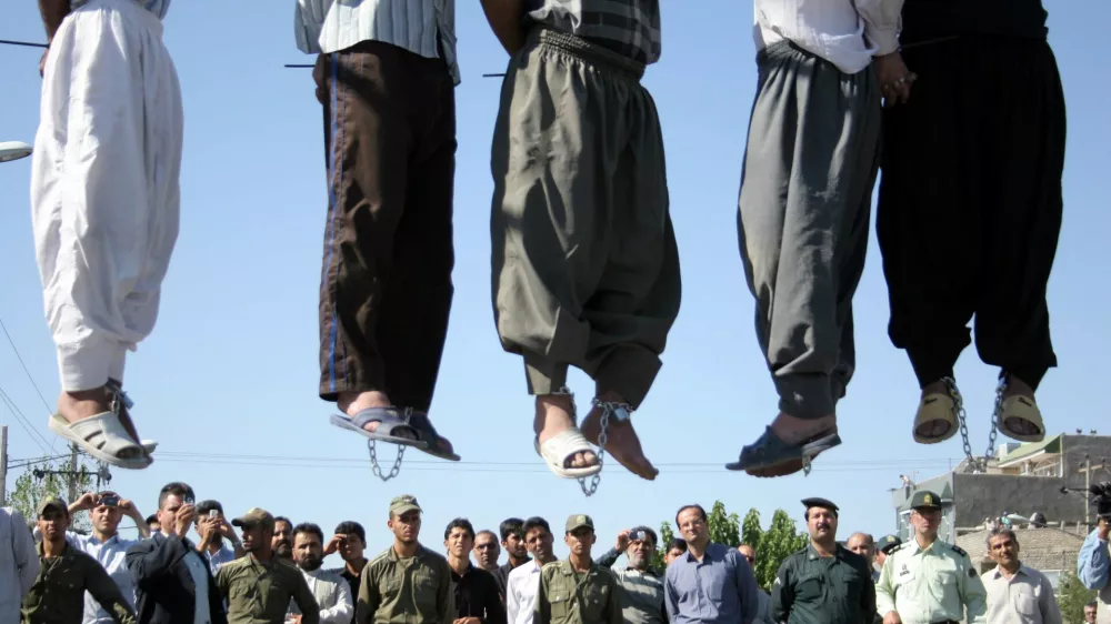 ** GRAPHIC CONTENT ** Iranian police officers and others view the scene as five convicted criminals are hanged in a neighborhood of Mashad, 1,000 kilometers (620 miles) northwest of Tehran, Iran, Wednesday Aug. 1, 2007. In the second round of collective executions in ten days, Iran on Wednesday publicly hanged 7 criminals convicted on various charges of rape, robbery and kidnapping, according to reports on the official web-site of state broadcasting company. (AP Photo/Halabisaz)