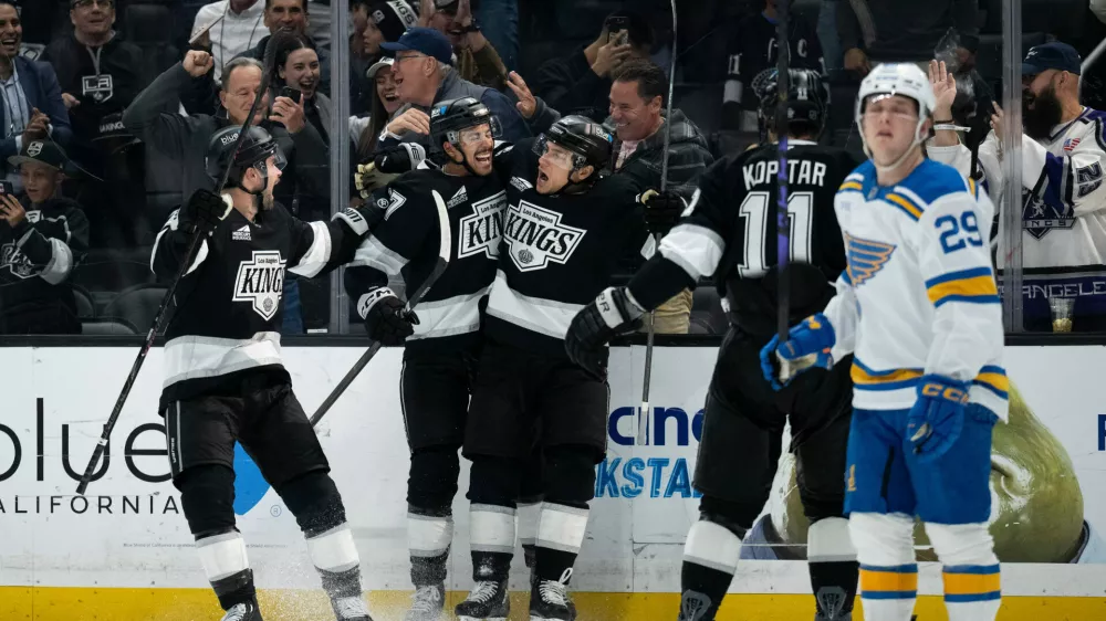 Los Angeles Kings left wing Trevor Moore, center, celebrates his game-winning goal with his teammates during overtime in an NHL hockey game against the St. Louis Blues, Wednesday, April 1, 2026, in Los Angeles. (AP Photo/Kyusung Gong)