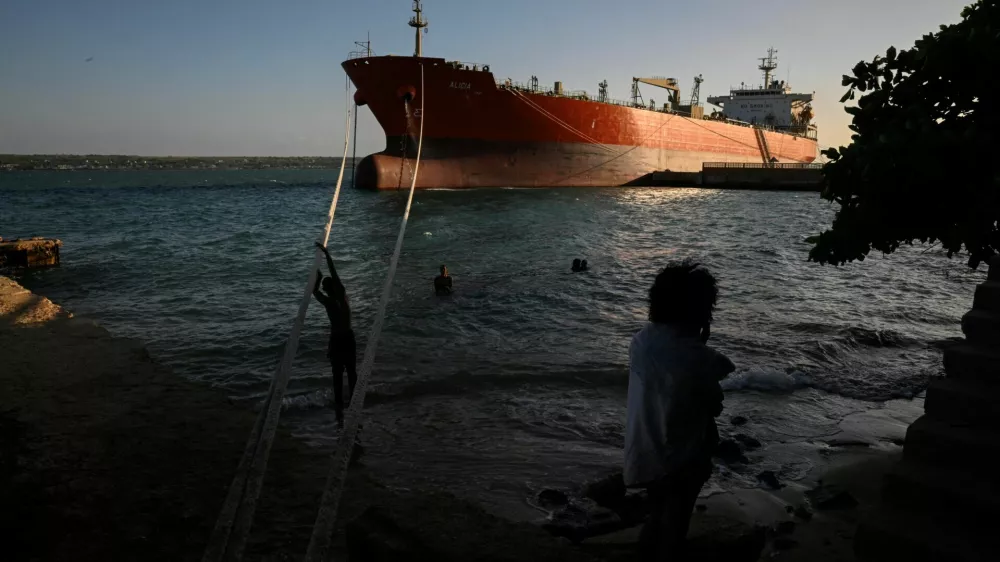 People spend time near the Cuban-flagged tanker Alicia moored at the Matanzas terminal as Cuba awaits the arrival of the Russian-flagged tanker Anatoly Kolodkin with oil, amid a months-long energy crisis since President Donald Trump's administration cut off its fuel supply, in Matanzas, Cuba, March 30, 2026. REUTERS/Norlys Perez