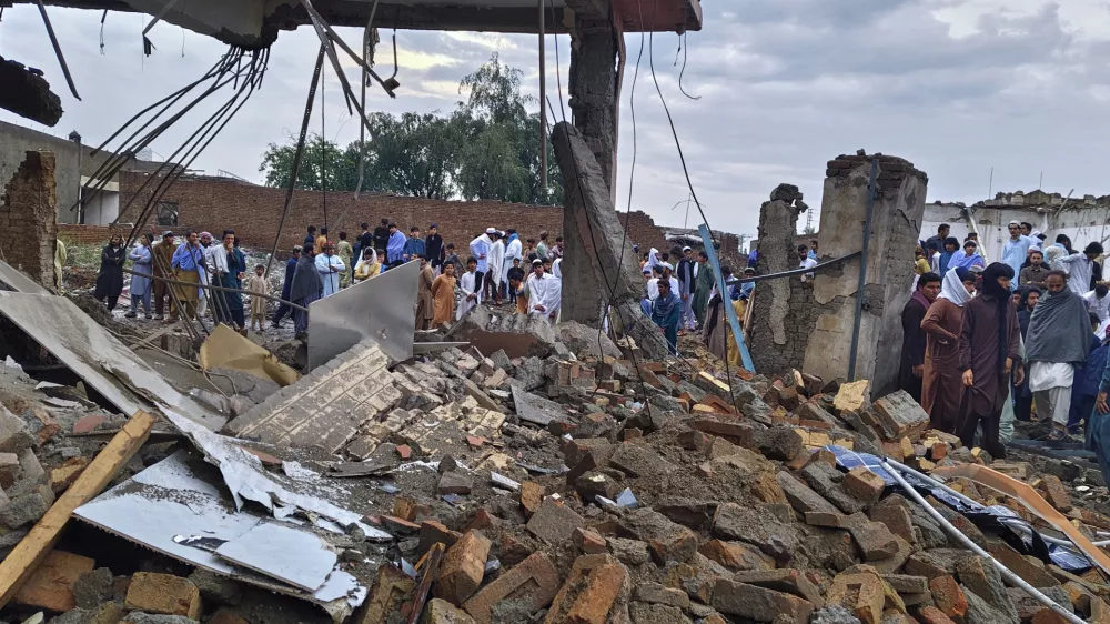 Local residents look at a damaged area of a police station after an overnight deadly bombing in the Bannu district of northwestern Pakistan, Friday, April 3, 2026. (AP Photo/Amaad Khattak)