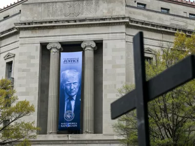 A cross carried as part of a Way of the Cross procession to mark Good Friday passes the U.S. Department of Justice building as it takes place in Washington, D.C., U.S., April 3, 2026. REUTERS/Annabelle Gordon