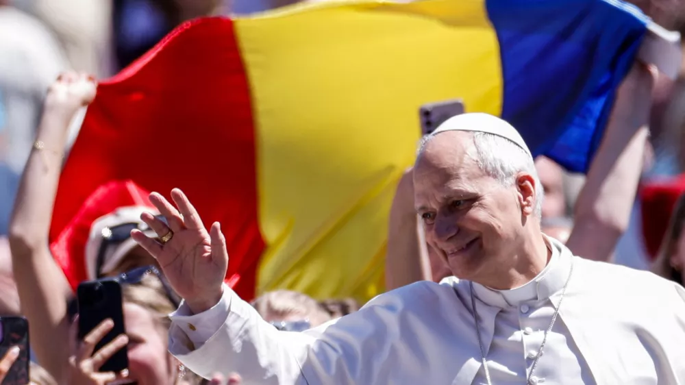Faithful hold a Romanian flag as Pope Leo XIV waves from the popemobile after delivering his "Urbi et Orbi" (To the city and the world) message, on Easter Sunday, at the Vatican, April 5, 2026. REUTERS/Remo Casilli