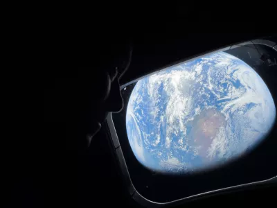  This image provided by NASA, astronaut and Artemis II Commander Reid Wiseman peers out of one of the Orion spacecraft's main cabin windows, looking back at Earth, as the crew travels towards the Moon on Thursday, April 2, 2026. (NASA via AP)