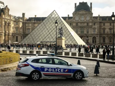 FILE - A police car parks in the courtyard of the Louvre museum, one week after the robbery, on Oct. 26, 2025, in Paris. (AP Photo/Thomas Padilla, File)