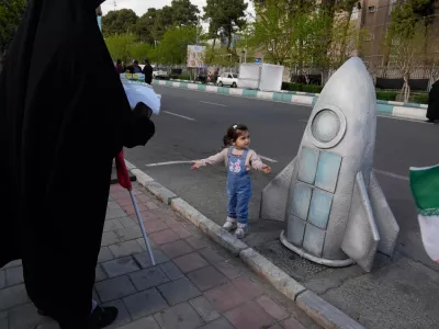 A girl stands next to replica of a space craft in a memorial for school children who were killed during a strike on a school in southern town of Minab on Feb. 28, in downtown Tehran, Iran, Tuesday, April 7, 2026. (AP Photo/Vahid Salemi)