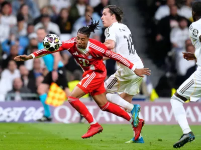 Bayern's Michael Olise, left, and Real Madrid's Alvaro Carreras vie for the ball during the Champions League quarterfinal first leg soccer match between Real Madrid and Bayern Munich in Madrid, Spain, Tuesday, April 7, 2026. (AP Photo/Jose Breton)