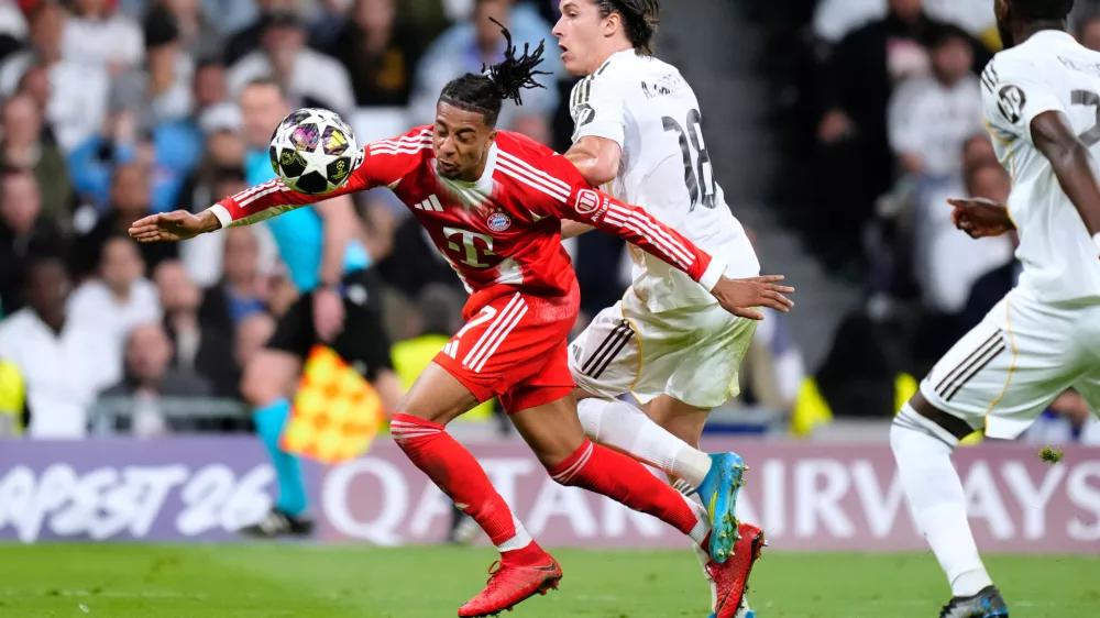Bayern's Michael Olise, left, and Real Madrid's Alvaro Carreras vie for the ball during the Champions League quarterfinal first leg soccer match between Real Madrid and Bayern Munich in Madrid, Spain, Tuesday, April 7, 2026. (AP Photo/Jose Breton)