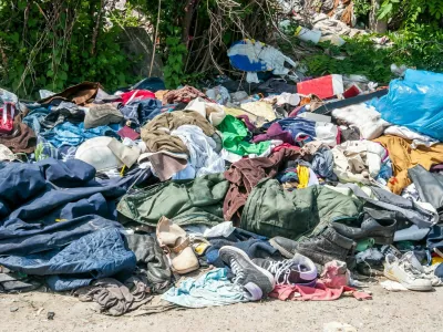 Pile of old clothes and shoes dumped on the grass as junk and garbage, littering and polluting the environment / Foto: Srdjanns74