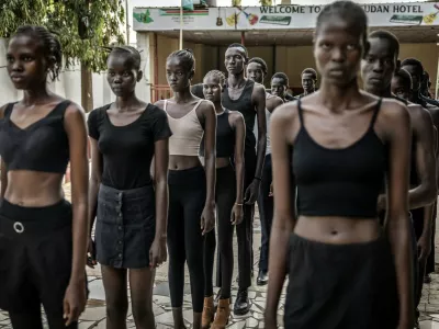 Professional models from the Juba-based modelling agency Jubalicious listen to instructions from a coach during a modelling training session at a hotel in Juba on February 19, 2026. Heels click on cracked paving stones as fantastically long-limbed men and women practice moves they hope will whisk them away from South Sudan, one of the fashion world's favourite scouting locations.Many hope to follow in the footsteps of their compatriot Awar Odhiang, who went from a refugee camp in Ethiopia to closing Chanel's Paris Fashion Week show last year. South Sudan has been mired in conflict, poverty and corruption since its independence in 2011, but the success of its models has been a ray of positivity. No less than nine of the top 50 models currently listed on Models.com are originally from the east African country.,Image: 1082447914, License: Rights-managed, Restrictions: TO GO WITH AFP STORY BY Rose TROUP BUCHANAN, Model Release: no