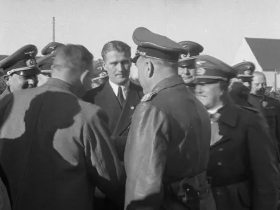 Von Braun med somi&scaron;ljeniki. Na oblačilu nosi značko nacistične stranke. / Foto: Wikipedia