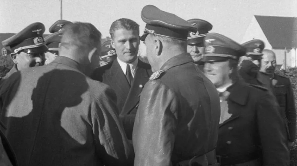 Von Braun med somi&scaron;ljeniki. Na oblačilu nosi značko nacistične stranke. / Foto: Wikipedia