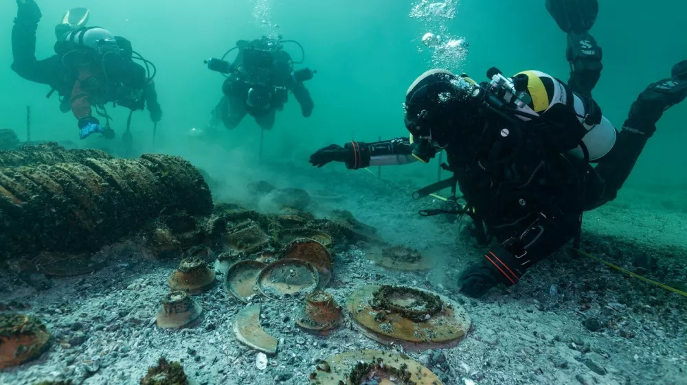 EXCLUSIVE: Story from Jam Press (Roman Shipwreck Hoard)Perfectly persevered treasure from 2,000-year old shipwreck found by diversDivers have uncovered a stunning haul of perfectly preserved treasure from a 2,000-year-old Roman shipwreck lying at the bottom of a lake.Hundreds of ancient objects were found resting on the lakebed &ndash; exactly where they settled when the vessel sank centuries ago.Remarkably, while the boat itself has long since vanished, its cargo remains largely intact.The incredible discovery was made in Lake Neuch&acirc;tel, Switzerland, after aerial photography in November 2024 spotted signs of submerged heritage.Follow-up dives and a full excavation in March 2025 revealed the extraordinary find, as reported by&nbsp;creatorzine.com.The operation is being led by the Cantonal Archaeology Office of Neuch&acirc;tel (OARC), alongside the Octopus Foundation and the Archaeological Service of the State of Fribourg.In a statement, officials said: "The richness and diversity of this collection of goods, in an excellent state of preservation, make this discovery exceptional, unique in Switzerland and in the inland waters north of the Alps."Experts believe the cargo dates from between 20 and 50 AD and once belonged to a Roman merchant vessel.Archaeologists said the find is particularly rare as the goods were not scattered, but preserved in a tight cluster &ndash; still reflecting how they had originally been packed and transported.But the race is now on to protect the fragile site.OARC warned the wreck is under threat from erosion, boat anchors and even looters.In a statement, the organisation said the cargo is exposed to "erosion of the lake bed, the anchoring of pleasure boats&hellip; and above all acts of vandalism and looting".They added that the most vulnerable items have already been recovered as a precaution.The haul includes hundreds of intact ceramic vessels &ndash; such as dishes, plates, bowls and cups &ndash; produced across the S.31 Mar 2026Pictured: Story from Jam Press (Roman Shipwreck Hoard)Perfectly persevered treasure from 2,000-year old shipwreck found by diversDivers have uncovered a stunning haul of perfectly preserved treasure from a 2,000-year-old Roman shipwreck lying at the bottom of a lake.Hundreds of ancient objects were found resting on the lakebed &ndash; exactly where they settled when the vessel sank centuries ago.Remarkably, while the boat itself has long since vanished, its cargo remains largely intact.The incredible discovery was made in Lake Neuch&acirc;tel, Switzerland, after aerial photography in November 2024 spotted signs of submerged heritage.Follow-up dives and a full excavation in March 2025 revealed the extraordinary find, as reported by&nbsp;creatorzine.com.The operation is being led by the Cantonal Archaeology Office of Neuch&acirc;tel (OARC), alongside the Octopus Foundation and the Archaeological Service of the State of Fribourg.In a statement, officials said: "T.,Image: 1087720683, License: Rights-managed, Restrictions: NO Australia, Germany, Norway, South Korea, Sweden, United Kingdom, United States, Unknown Country, Model Release: no, Pictured: Divers exploring the shipwreck