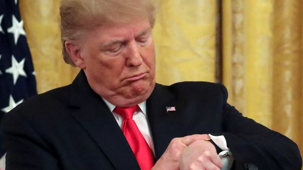 FILE PHOTO: U.S. President Donald Trump checks his watch during an event to celebrate federal judicial confirmations in the East Room of the White House in Washington, D.C., U.S., November 6, 2019. REUTERS/Jonathan Ernst/File Photo
