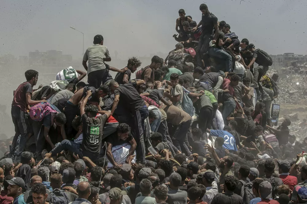 West, Central, and South Asia | Singles | Aid Emergency in GazaPalestinians climb onto an aid truck as it enters the Gaza Strip via the Zikim Crossing in an attempt to get flour, during what the Israeli military called a 'tactical suspension' in operations to allow humanitarian aid through. Northern Gaza Strip, 27 July 2025. In 2025, famine took hold amid what a UN commission has concluded is a genocide in Gaza, which Israel disputes. The UN reports that between 27 May and 31 July at least 1,373 Palestinians seeking food were killed at or near aid distribution sitesPhotograph: Saber Nuraldin, EPA Images/World Press Photo 2026
