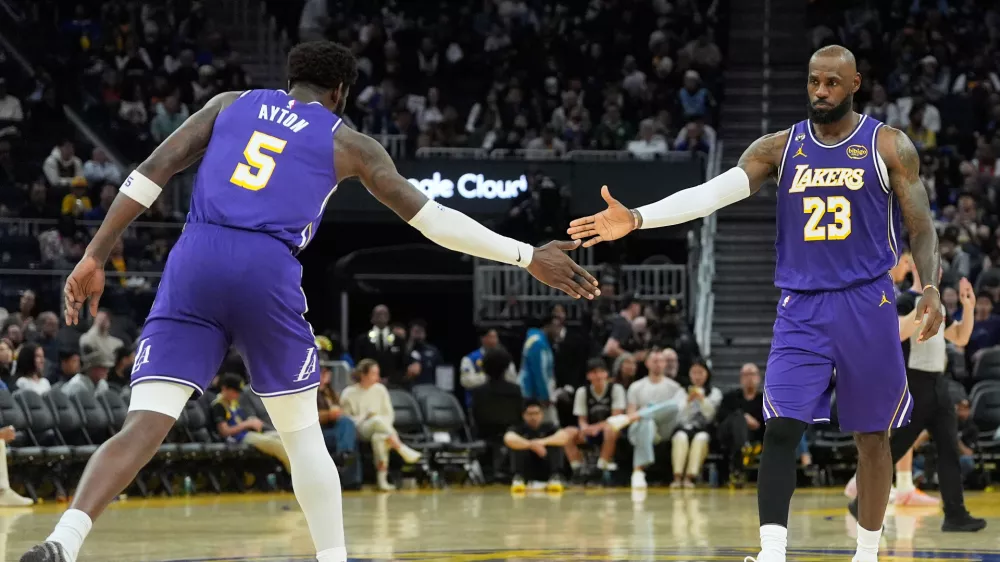 Los Angeles Lakers center Deandre Ayton (5) celebrates with forward LeBron James (23) during the second half of an NBA basketball game against the Golden State Warriors in San Francisco, Thursday, April 9, 2026. (AP Photo/Jeff Chiu)