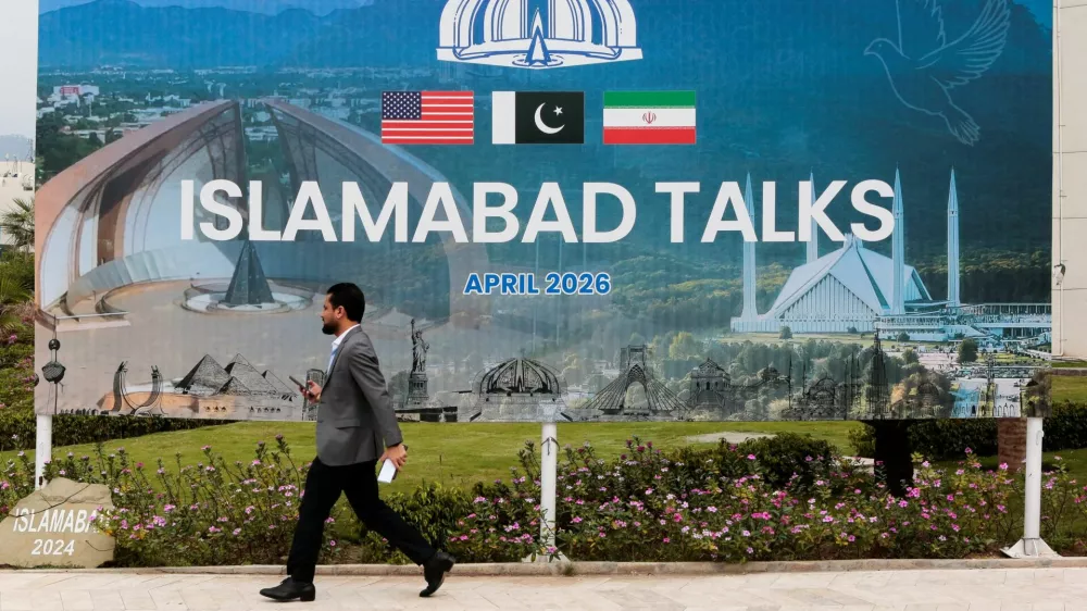 A man walks past a billboard near the media centre as delegations from the United States and Iran are expected to hold high-stakes talks in Islamabad, Pakistan, April 11, 2026. REUTERS/Asim Hafeez   TPX IMAGES OF THE DAY