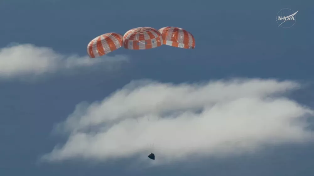 In this image from video provided by NASA, the Artemis II Orion capsule uses parachutes to decelerate for splashdown in the Pacific Ocean, on Friday, April 10, 2026. (NASA via AP)