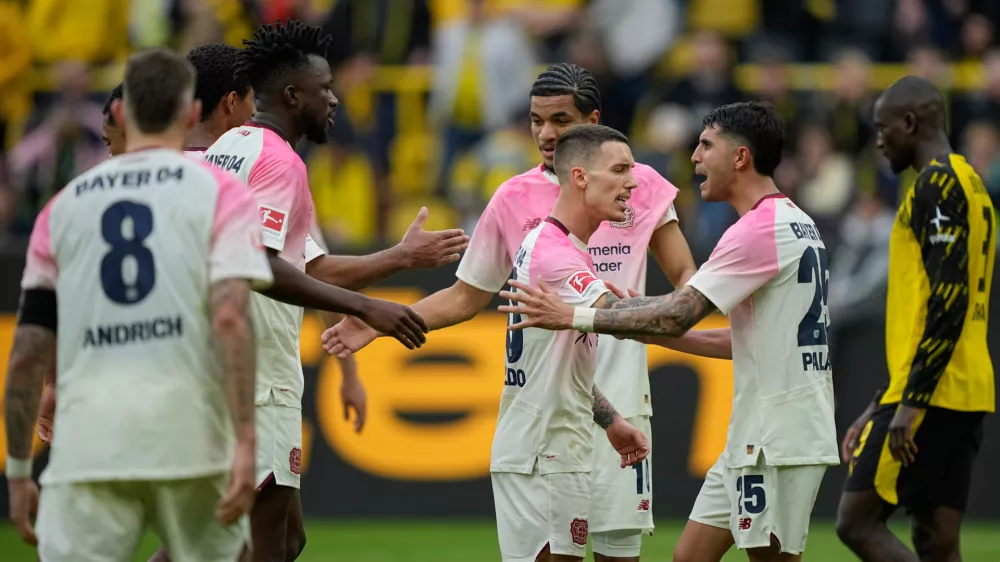 Leverkusen' players celebrate after winning the German Bundesliga soccer match between Borussia Dortmund and Bayer Leverkusen in Dortmund, Germany, Saturday, April 11, 2026. (AP Photo/Martin Meissner)