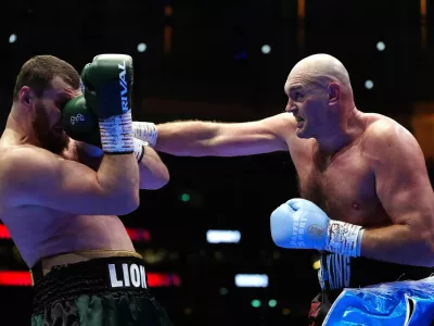 Boxer Tyson Fury, right, punches Arslanbek Makhmudov during a heavyweight bout at Tottenham Hotspur Stadium in London, Saturday, April 11, 2026. (Bradley Collyer/PA via AP)