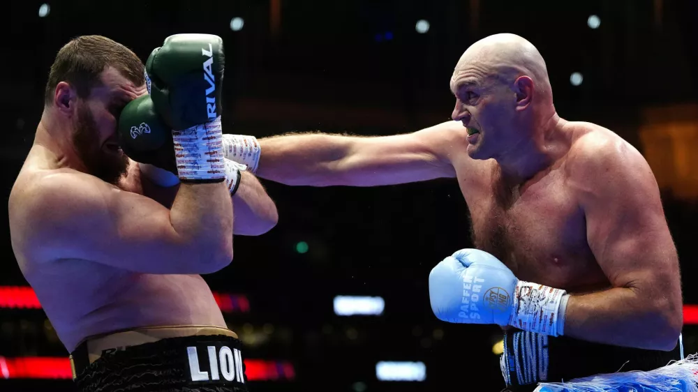 Boxer Tyson Fury, right, punches Arslanbek Makhmudov during a heavyweight bout at Tottenham Hotspur Stadium in London, Saturday, April 11, 2026. (Bradley Collyer/PA via AP)