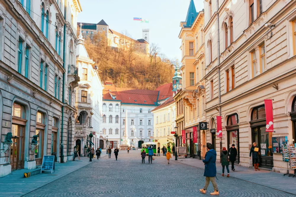 Ljubljana, Slovenia - January 15, 2019: Tourists on Stritarjeva Ulica Street and cityscape of Ljubljana old town with Castle, Slovenia, Europe. People in Slovenian city view in winter. Urban capital.