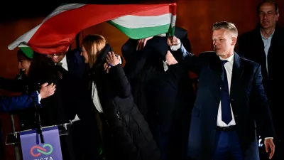 Peter Magyar, leader of the opposition Tisza party, holds a national flag following the partial results of the parliamentary election, in Budapest, Hungary, April 12, 2026. REUTERS/Marton Monus