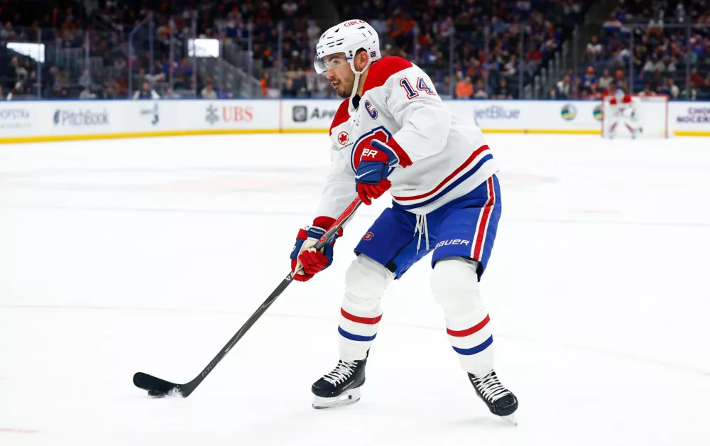 Montr&eacute;al Canadiens center Nick Suzuki controls the puck against the New York Islanders during the first period of an NHL hockey game, Sunday, April 12, 2026, in Elmont, N.Y. (AP Photo/Noah K. Murray)