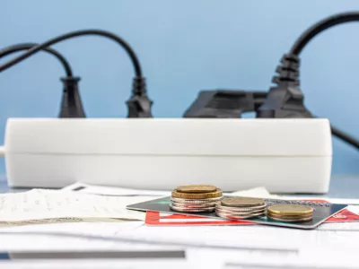 The Money, bank credit cards and electricity bills on the background of an electrical outlet. Electricity debts, the concept of rising electricity prices.