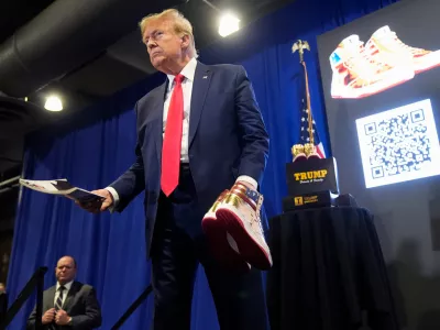 FILE - Donald Trump hold a Playboy magazine and gold Trump sneakers at Sneaker Con Philadelphia, an event popular among sneaker collectors, in Philadelphia, Saturday, Feb. 17, 2024. (AP Photo/Manuel Balce Ceneta, File)
