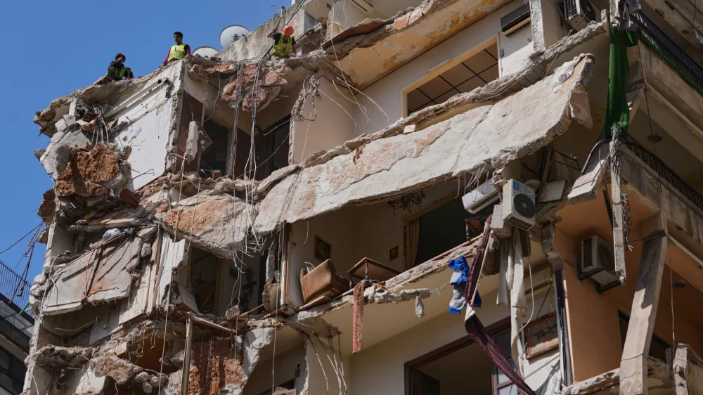 Workers remove the rubble as rescuers keep searching for a missing woman and girl at a destroyed building that was hit on April 8, in an Israeli airstrike in Beirut, Lebanon, Monday, April 13, 2026. (AP Photo/Hussein Malla)