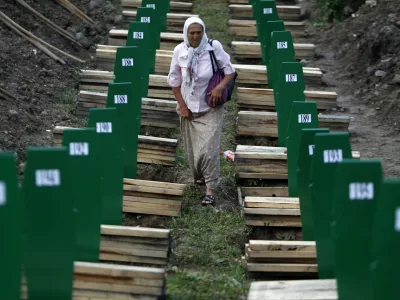 A Bosnian woman searches for her relative after 409 coffins of newly identified victims from the 1995 Srebrenica massacre were uncovered, in Potocari Memorial Center, near Srebrenica July 10, 2013. The bodies of the recently identified victims will be buried on July 11 marking the 18th anniversary of the massacre in which Bosnian Serb forces commanded by Ratko Mladic killed up to 8,000 Muslim men and boys and buried them in mass graves. REUTERS/Dado Ruvic (BOSNIA AND HERZEGOVINA - Tags: CIVIL UNREST SOCIETY)