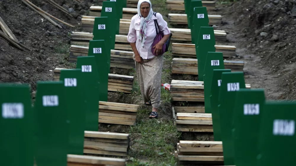 A Bosnian woman searches for her relative after 409 coffins of newly identified victims from the 1995 Srebrenica massacre were uncovered, in Potocari Memorial Center, near Srebrenica July 10, 2013. The bodies of the recently identified victims will be buried on July 11 marking the 18th anniversary of the massacre in which Bosnian Serb forces commanded by Ratko Mladic killed up to 8,000 Muslim men and boys and buried them in mass graves. REUTERS/Dado Ruvic (BOSNIA AND HERZEGOVINA - Tags: CIVIL UNREST SOCIETY)