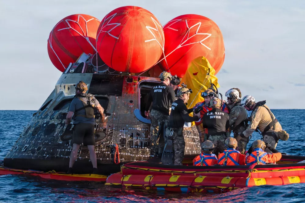 NASA Astronaut Reid Wiseman, Artemis II mission commander, exits the Orion crew module to join the three other crew in a raft, before transiting to the U.S. Navy ship USS John P. Murtha in the Pacific Ocean off the coast of California, U.S. April 10, 2026. NASA's Artemis II mission sent four astronauts on a flight around the moon in the Orion space capsule, which splashed down after the ten day journey. U.S. Navy/Mass Communication Specialist David Rowe/Handout via REUTERS THIS IMAGE HAS BEEN SUPPLIED BY A THIRD PARTY. THIS IMAGE WAS PROCESSED BY REUTERS TO ENHANCE QUALITY, AN UNPROCESSED VERSION HAS BEEN PROVIDED SEPARATELY.
