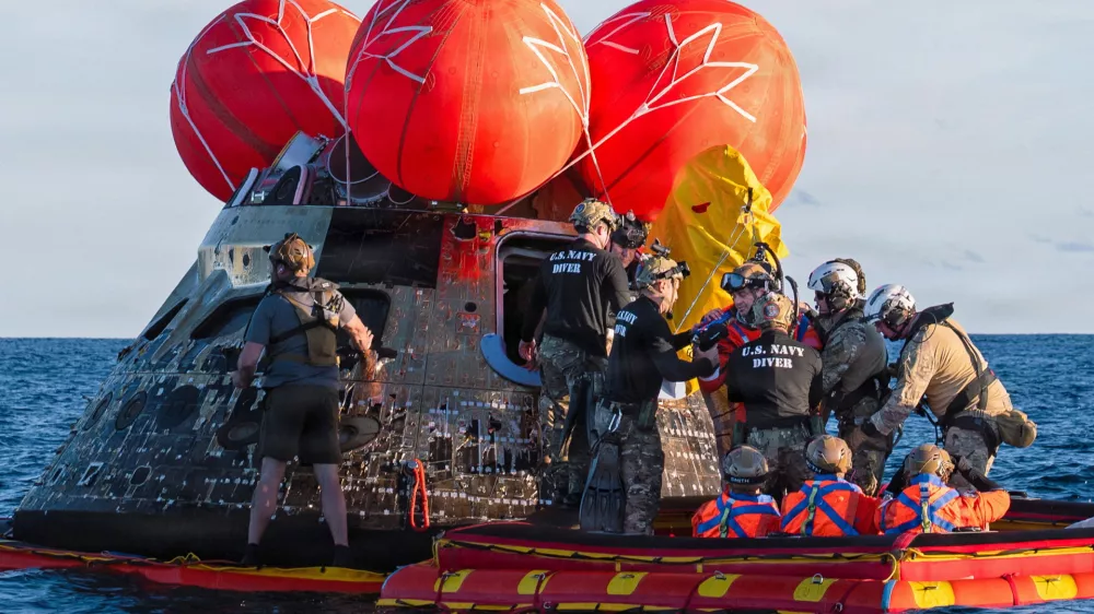 NASA Astronaut Reid Wiseman, Artemis II mission commander, exits the Orion crew module to join the three other crew in a raft, before transiting to the U.S. Navy ship USS John P. Murtha in the Pacific Ocean off the coast of California, U.S. April 10, 2026. NASA's Artemis II mission sent four astronauts on a flight around the moon in the Orion space capsule, which splashed down after the ten day journey. U.S. Navy/Mass Communication Specialist David Rowe/Handout via REUTERS THIS IMAGE HAS BEEN SUPPLIED BY A THIRD PARTY. THIS IMAGE WAS PROCESSED BY REUTERS TO ENHANCE QUALITY, AN UNPROCESSED VERSION HAS BEEN PROVIDED SEPARATELY.