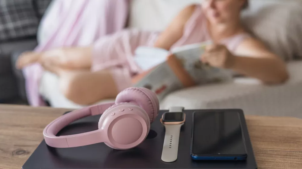 Engaging in a digital detox by relaxing on the couch, reading a book, while enjoying a peaceful afternoon indoors. / Foto: Alina Kandybka Getty Images