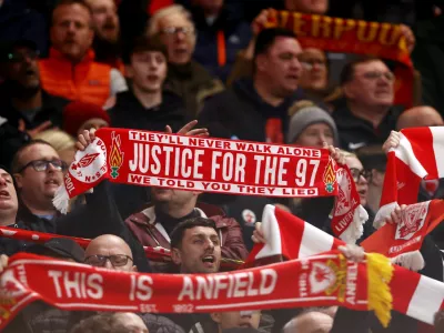 Soccer Football - UEFA Champions League - Quarter Final - Second Leg - Liverpool v Paris St Germain - Anfield, Liverpool, Britain - April 14, 2026 A Liverpool fan holds a scarf in memory of the 97 victims of the Hillsborough disaster inside the stadium before the match Action Images via Reuters/Lee Smith
