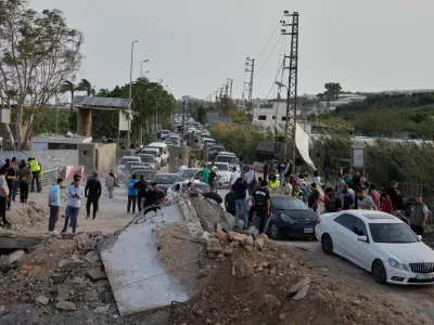 Displaced people returning to their villages following a ceasefire between Hezbollah and Israel, cross the destroyed Qasmiyeh bridge near Tyre city, south Lebanon, Friday, April 17, 2026. (AP Photo/Mohammed Zaatari)